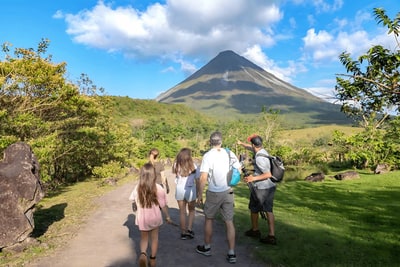 A family and their guide walking a trail toward Arenal Volcano, Costa Rica